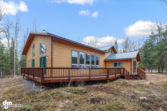 back of property with a wooden deck and metal roof