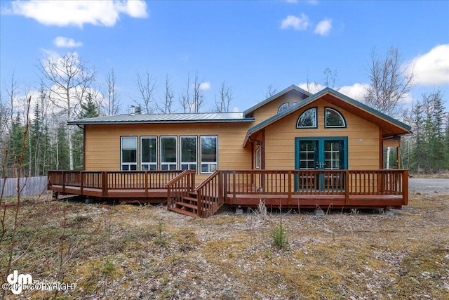 rear view of property featuring metal roof and a deck