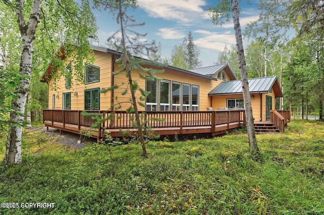 rear view of property featuring a standing seam roof, metal roof, and a deck