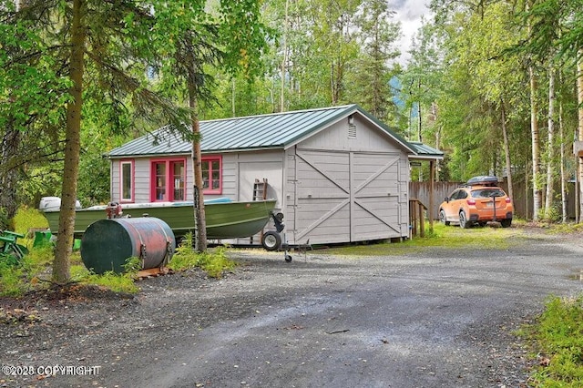 view of outbuilding featuring heating fuel and fence