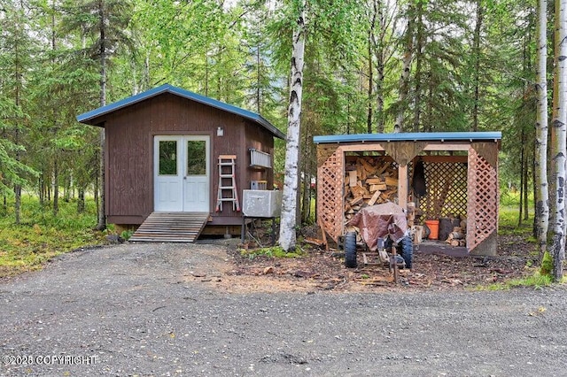 view of outbuilding featuring a forest view and an outdoor structure