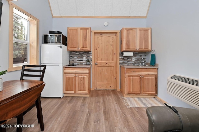 36696 Tammarack St, Soldotna, AK 99669 - kitchen featuring freestanding refrigerator, decorative backsplash, lofted ceiling, light wood-type flooring, and light countertops