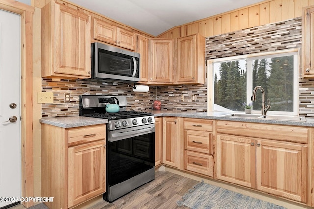 36696 Tammarack St, Soldotna, AK 99669 - kitchen featuring decorative backsplash, a sink, light wood finished floors, light brown cabinets, and stainless steel appliances