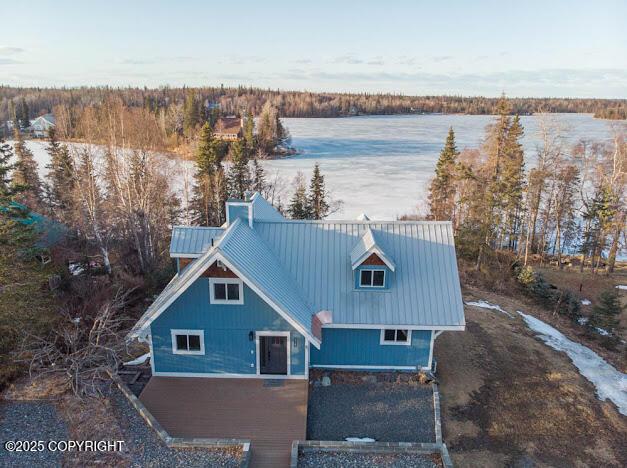 birds eye view of property featuring a forest view and a water view