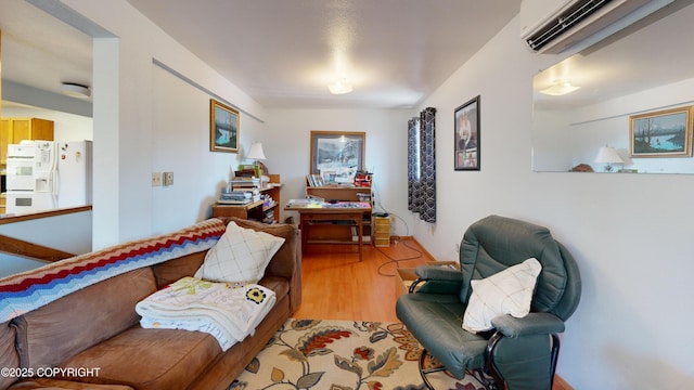 sitting room featuring light wood-type flooring and a wall mounted air conditioner