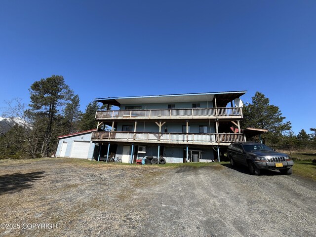 view of front of home with a wooden deck, driveway, and a detached garage