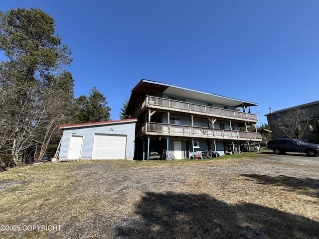 back of property featuring a garage and a deck