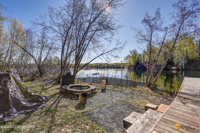 view of yard with an outdoor fire pit and a water view