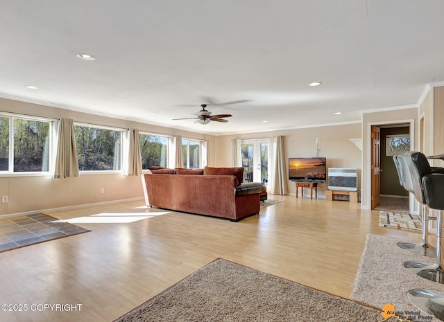 living room featuring crown molding, a ceiling fan, light wood finished floors, heating unit, and recessed lighting