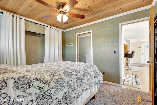 carpeted bedroom with wooden ceiling, ornamental molding, a closet, a ceiling fan, and baseboards