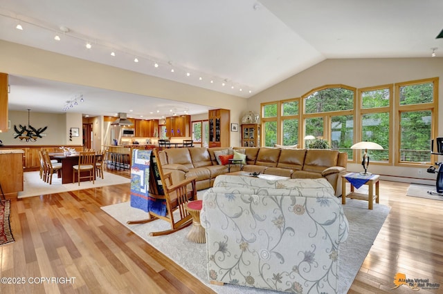 16900 Ransom Ridge Rd, Anchorage, AK 99516 - living room featuring light wood-style floors, a chandelier, and vaulted ceiling