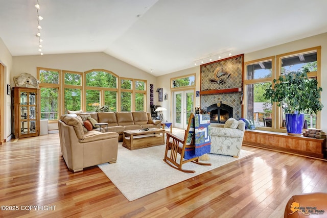 16900 Ransom Ridge Rd, Anchorage, AK 99516 - living area with rail lighting, light wood-style flooring, a tile fireplace, and lofted ceiling
