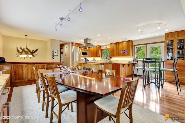 16900 Ransom Ridge Rd, Anchorage, AK 99516 - dining room with rail lighting, a chandelier, and light wood-type flooring