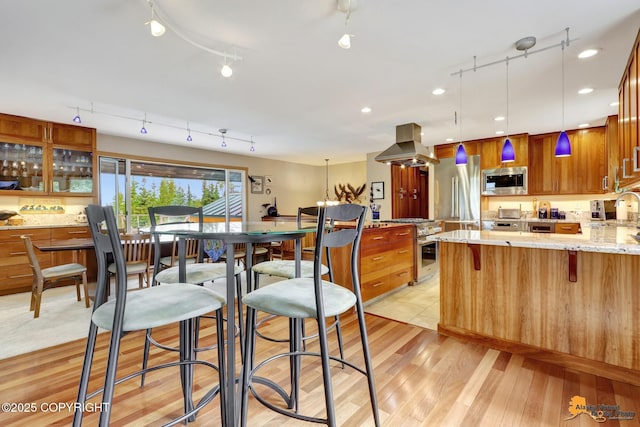 16900 Ransom Ridge Rd, Anchorage, AK 99516 - kitchen featuring stainless steel appliances, island exhaust hood, track lighting, and a peninsula