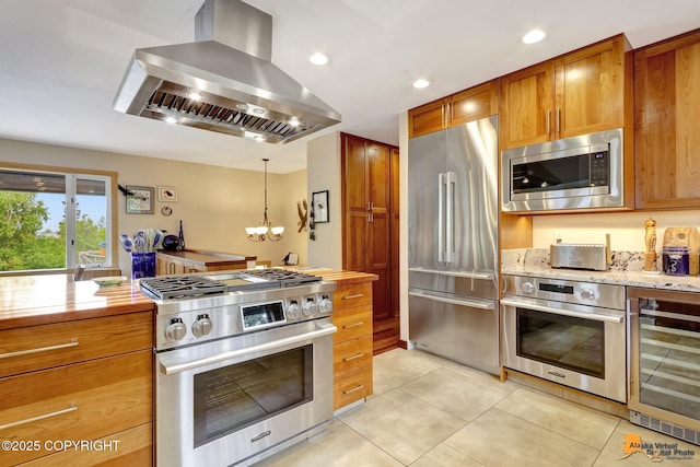16900 Ransom Ridge Rd, Anchorage, AK 99516 - kitchen featuring appliances with stainless steel finishes, exhaust hood, wine cooler, light tile patterned floors, and a chandelier
