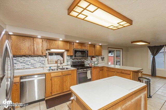 10209 Colville St, Eagle River, AK 99577 - kitchen with appliances with stainless steel finishes, a sink, a peninsula, light tile patterned floors, and backsplash