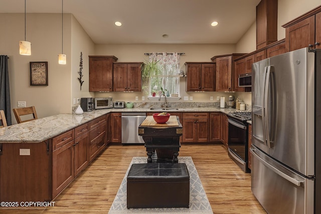 3604 N Copperspike St, Wasilla, AK 99623 - kitchen with stainless steel appliances, a peninsula, a sink, light wood-style floors, and light stone counters