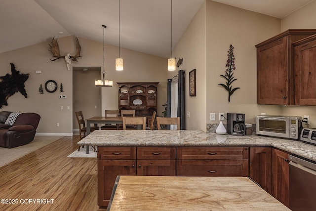 3604 N Copperspike St, Wasilla, AK 99623 - kitchen with stainless steel dishwasher, light wood finished floors, lofted ceiling, light stone countertops, and a peninsula