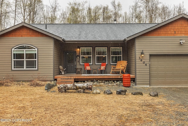 3604 N Copperspike St, Wasilla, AK 99623 - view of front of home with a porch, a shingled roof, and a garage