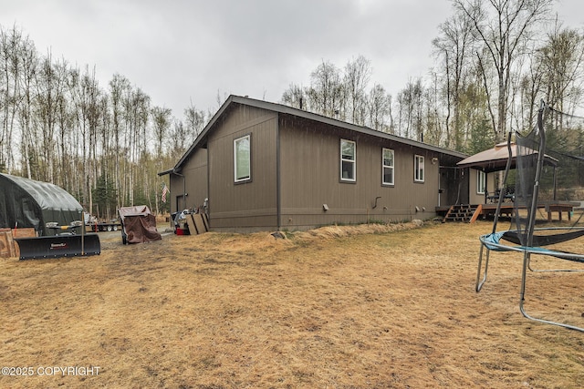 3604 N Copperspike St, Wasilla, AK 99623 - view of side of property with a trampoline, a gazebo, and a lawn