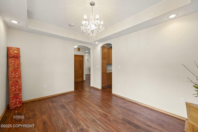 3600 N Fortune Cir, Wasilla, AK 99654 - unfurnished room featuring arched walkways, dark wood-type flooring, recessed lighting, baseboards, and a chandelier