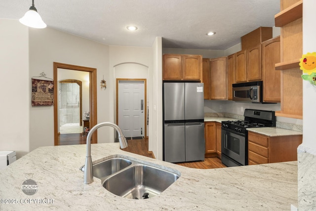3600 N Fortune Cir, Wasilla, AK 99654 - kitchen featuring appliances with stainless steel finishes, a sink, light wood finished floors, brown cabinets, and recessed lighting