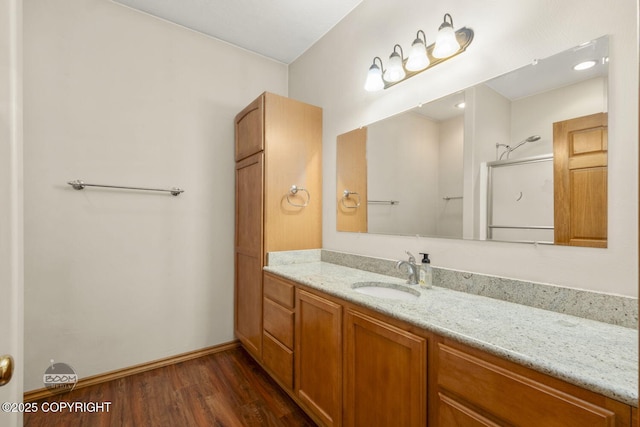 3600 N Fortune Cir, Wasilla, AK 99654 - bathroom featuring wood finished floors, vanity, a shower with shower door, and baseboards
