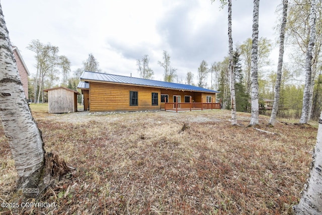 3600 N Fortune Cir, Wasilla, AK 99654 - back of house featuring a storage shed, metal roof, an outbuilding, covered porch, and log veneer siding
