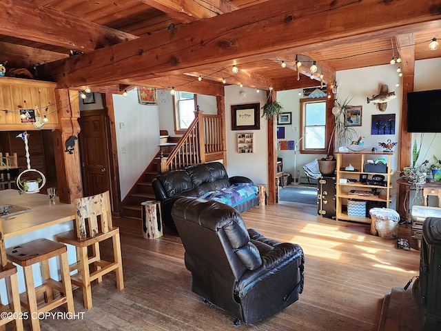 living area featuring wood ceiling, wood finished floors, beamed ceiling, and plenty of natural light