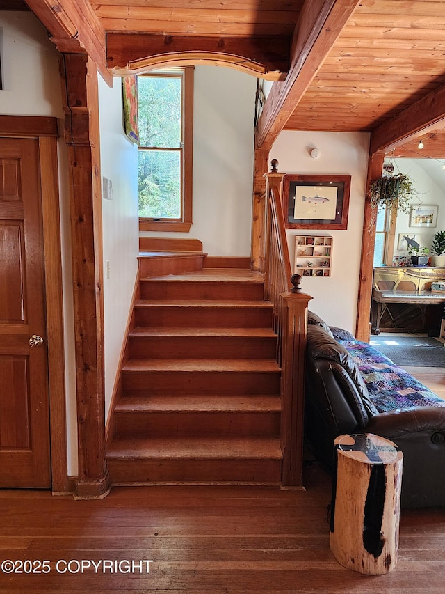 stairway featuring wood-type flooring and wooden ceiling