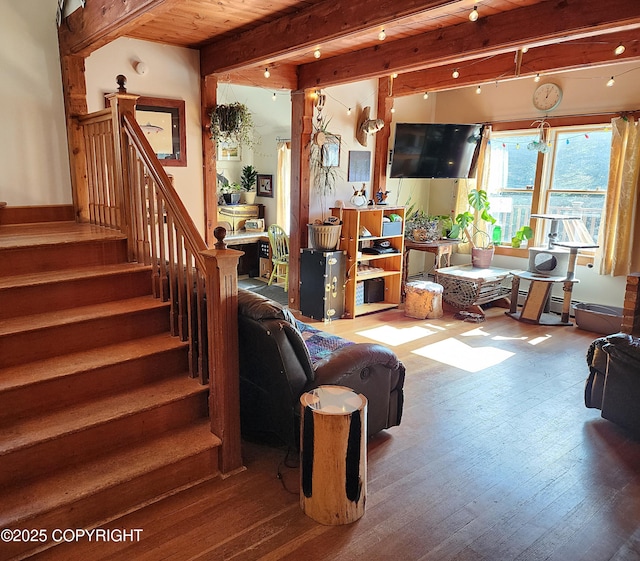 living area featuring beamed ceiling, hardwood / wood-style floors, stairs, and wood ceiling