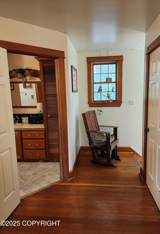 hall with light wood-style floors and baseboards