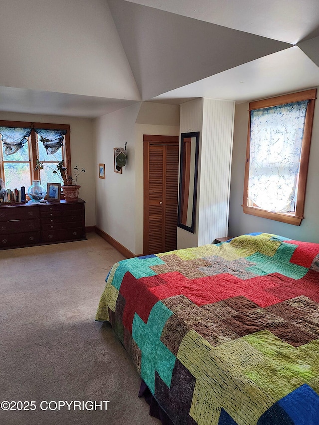 carpeted bedroom featuring vaulted ceiling, baseboards, and a closet