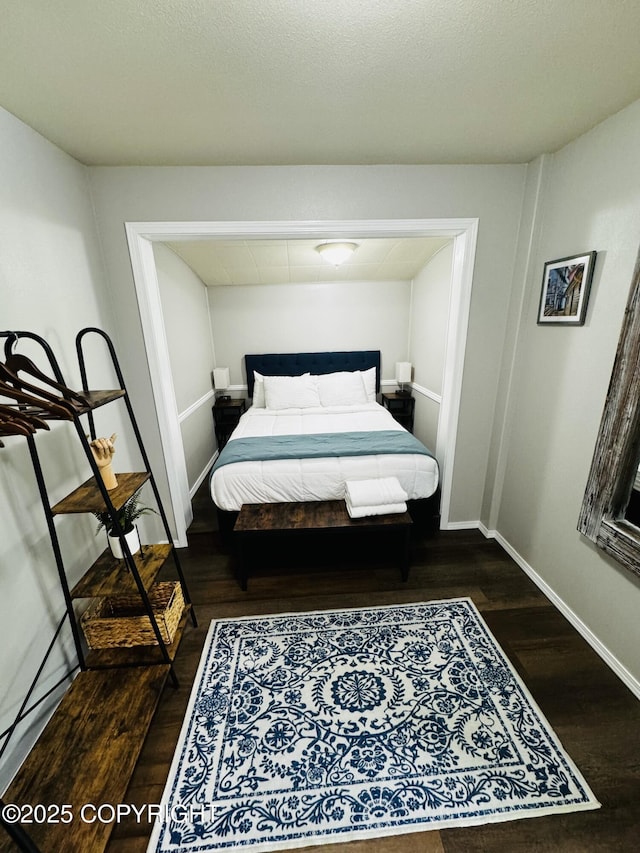 bedroom featuring baseboards and dark wood-style floors