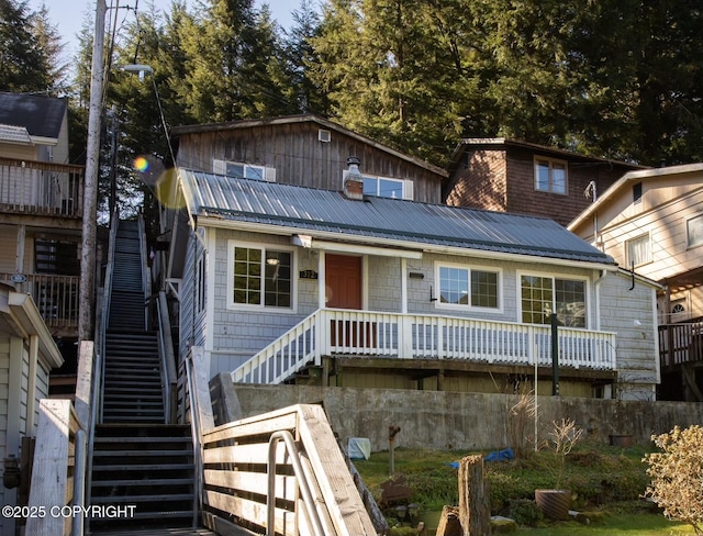 view of front of home with metal roof and stairway
