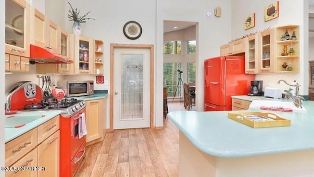 21899 Sterling Hwy, Cooper Landing, AK 99572 - kitchen with stainless steel microwave, fridge, open shelves, light wood-type flooring, and gas stove