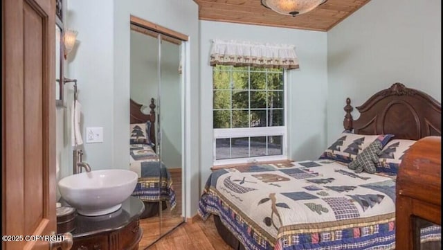 21899 Sterling Hwy, Cooper Landing, AK 99572 - bedroom with wood finished floors, wooden ceiling, a closet, and a sink