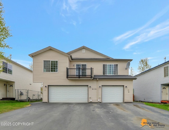 view of front of house with an attached garage, asphalt driveway, and a balcony