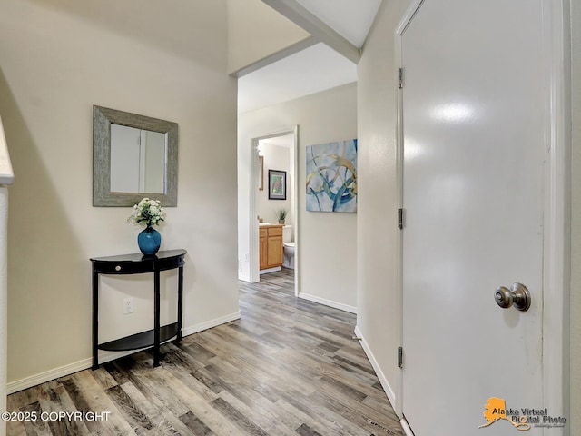 corridor with light wood-style floors and baseboards