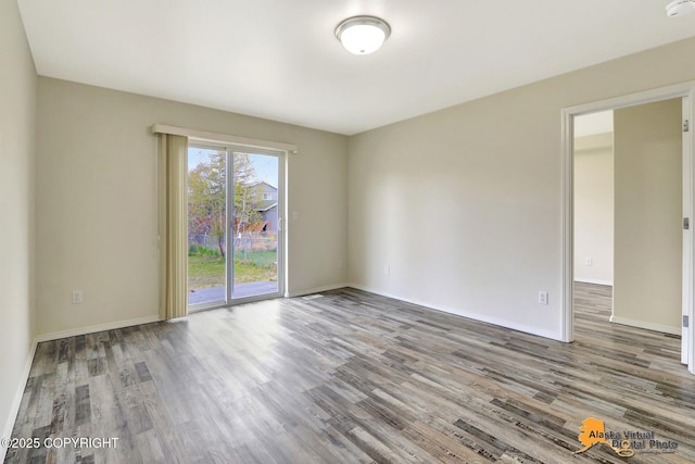 empty room featuring wood finished floors and baseboards