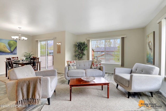 living area featuring a chandelier, wood finished floors, and baseboards