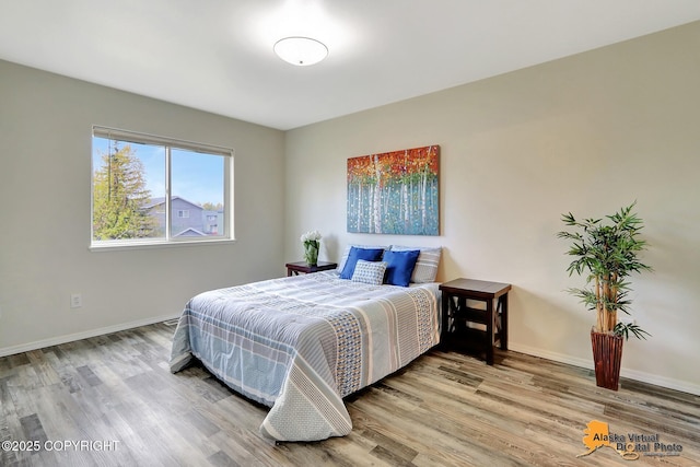 bedroom with wood finished floors and baseboards