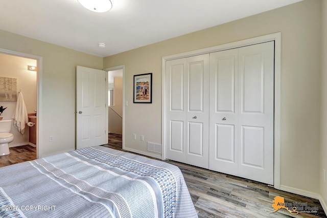 bedroom featuring wood finished floors, a closet, connected bathroom, and baseboards
