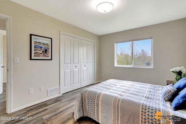 bedroom featuring wood finished floors, a closet, and baseboards