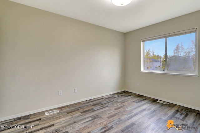 spare room with wood finished floors and baseboards