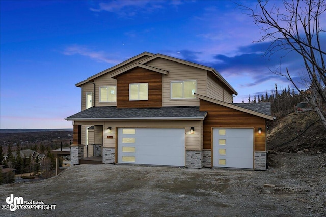 view of front of property featuring a shingled roof, an attached garage, and stone siding