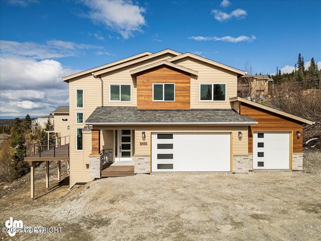 6485 Prominence Pointe Dr, Anchorage, AK 99516 - view of front of house featuring driveway, stone siding, roof with shingles, and covered porch