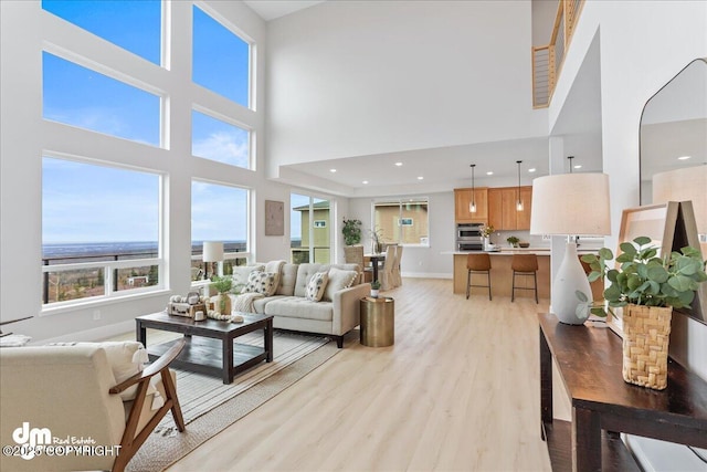 6485 Prominence Pointe Dr, Anchorage, AK 99516 - living area with a towering ceiling, light wood finished floors, baseboards, and recessed lighting