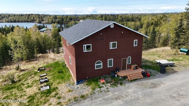 53160 Stol Rd, Clam Gulch, AK 99568 - view of property exterior with a view of trees, a shingled roof, and a deck with water view