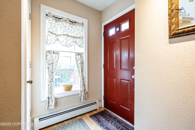 2000 Wenmatt Cir, Anchorage, AK 99517 - foyer entrance featuring a baseboard radiator, healthy amount of natural light, wood finished floors, and a textured wall